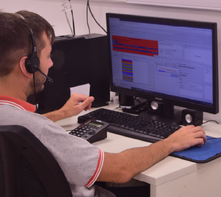 Hombre frente a la computadora brindando el servicio de monitoreo de alarmas.
